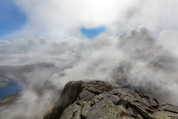 Fototapeta na wymiar Dramatic mountains Norway. Cloudy mountain top in Rosendal. Norwegian nature.