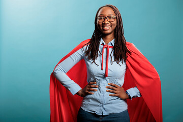 Proud superhero woman with superpower abilities wearing mighty hero cloak while smiling confident...