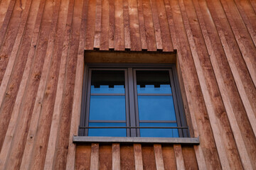 Single window in wood paneled house.