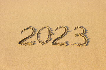2023 number on a sand beach. Abstract background photo of coming New Year 2023.