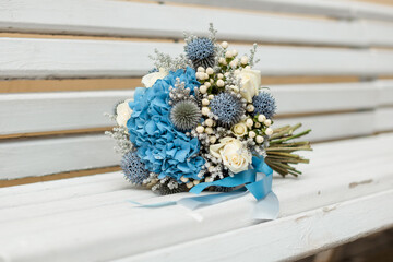 bouquet with blue flowers on a white bench