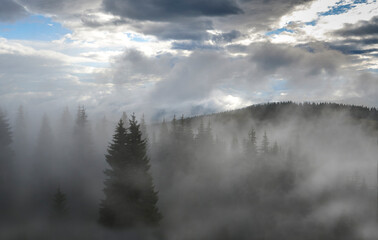 Fototapeta premium Incredible view of the Carpathian mountains early in the morning. sunrise in the mountains. Cloudy sky after rainy night on the top of the hill. Mountain valley at sunrise. Rain drops on lens