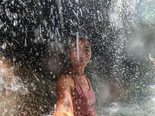 Tourist enjoying the hot spring waterfall of Finca Paraiso, Rio Dulce, Guatemala