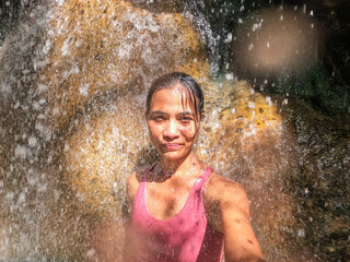 Fototapeta premium Tourist enjoying the hot spring waterfall of Finca Paraiso, Rio Dulce, Guatemala