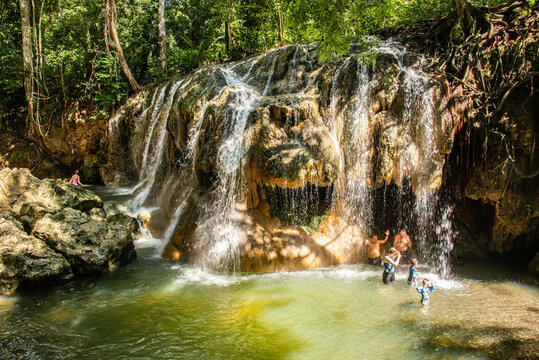 Tourists enjoying the hot spring waterfall of Finca Paraiso, Rio Dulce, Guatemala