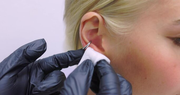 Professional holding the jewel of piercing day just before screw the ball. Tragus type.