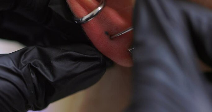 Professional holding the jewel of piercing day just before screw the ball. Tragus type.