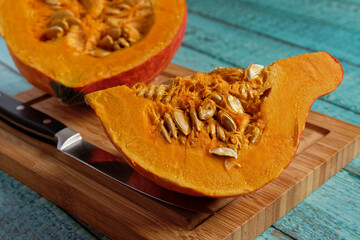 Hokkaido pumpkin cut open on a wooden cutting board