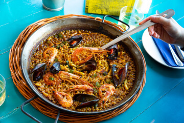 Spainsh dish seafood paella with rice, shrimps and mussels