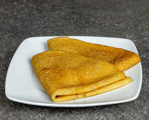 Two pancakes on a white plate close-up.
