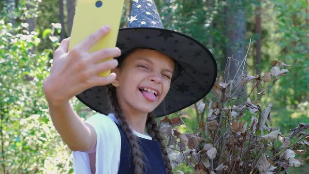 cute cheerful deovka teenager with smart phone in parkena halloween party, girl shoots video on phone,