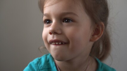 Portrait Funny little close up view happy preschool girl smiling child looking away thoughtfully, pretty natural face.sincere emotions of ashamed, embarrassed clean skin dermatology, pediatric