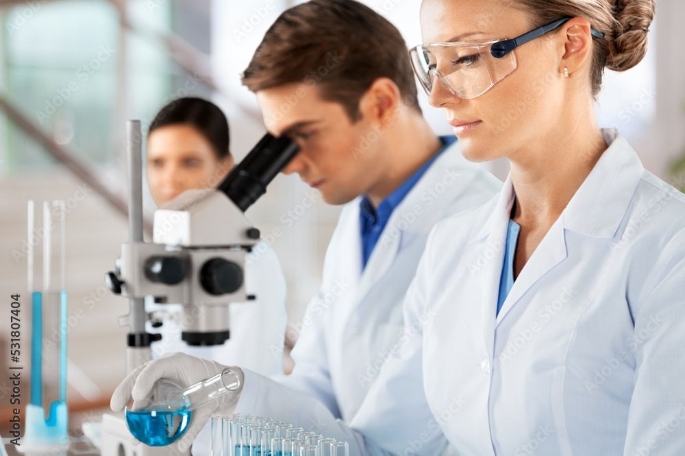Poster scientists with microscopes working with tests in laboratory