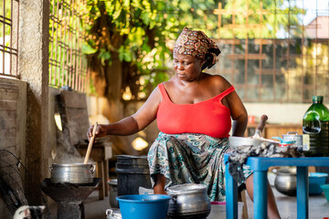 image of african woman stirring a pot- cooking concept