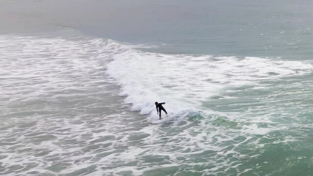 Surfer scatching a wave on a cloudy afternoon.