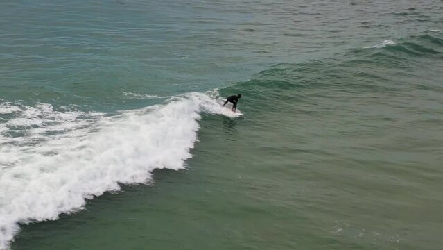 Surfer scatching a wave on a cloudy afternoon.