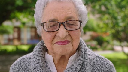 Elderly woman, glasses and portrait in park alone with proud and empowered face expression. Retirement life, relax and nature garden lady with vision specs for help with outdoor eyesight.