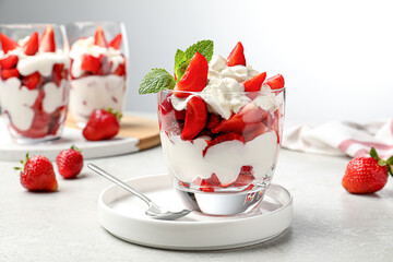 Delicious strawberries with whipped cream served on light grey table - Powered by Adobe