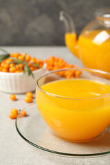 Fresh sea buckthorn tea on light table, closeup