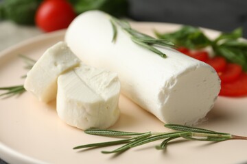 Delicious goat cheese with rosemary on plate, closeup