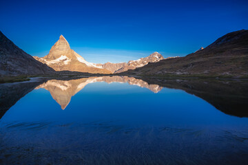 Fototapeta na wymiar Matterhorn iconic mountain and lake relfection at peaceful sunrise, Swiss Alps