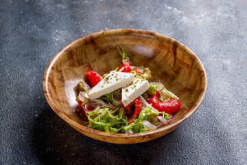 Greek salad with feta and vegetables on stone table