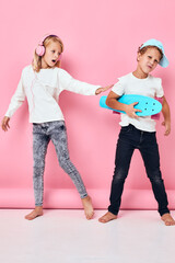 Couple of adorable stylish children skateboard headphones playing lifestyle childhood