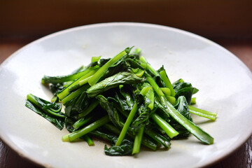 白い皿に乗った青菜炒め