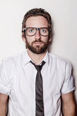 Caucasian blond-haired man with glasses, wearing a white shirt looking at the camera.