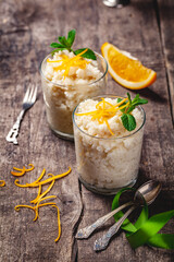 Two glasses of rice pudding on wooden rustic table. Close up
