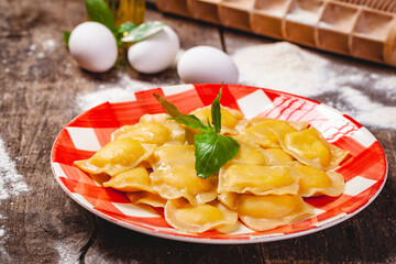 Homemade pumpkin ravioli on wooden rustic table. Close up