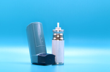Asthma inhaler with cartridge for breathing disease treatment on light blue background