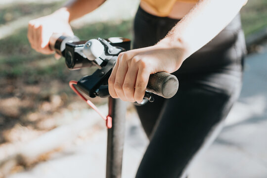 Close up of electric scooter handlebar pressing the brake and stopping.Rental application for citizens and tourists, moving around the city in a different way.Eco friendly vehicle and transportation