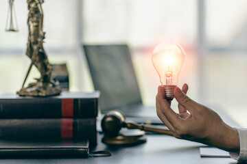 Close-up of a man holding a glowing light bulb with icons of ideas, innovation and business inspiration. Cyber ​​digital data saves energy