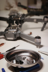 close up of different repairing tools and a drone, on white table