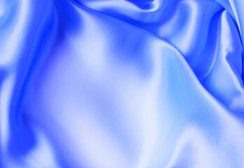 Beautiful light blue material folded into folds. Silk, satin. Solid background.