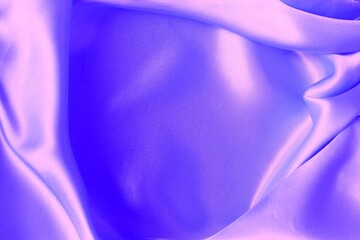 Beautiful purple material, folded in folds. Silk, satin. Solid background.