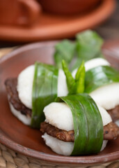 Jadah Tempe, food made from finely mashed glutinous rice and fried soy tempe. Traditional snacks for local afternoon tea time. On traditional plate. Selective Focus