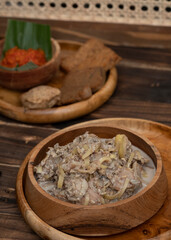 Indonesian coconut milk soup called sayur jantung pisang, made with banana's heart (ontong), coconut milk, cayenne pepper, and other spices . This one was served in a wooden bowl.