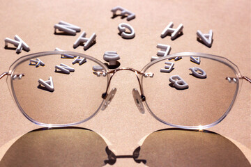 White letters in focus glasses on a brown background. Vision concept