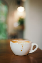 Coffee mug with coffee stain on wooden table blur indoor cafe background 