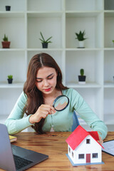 customer holding a magnifying glass to look at a house model inspection