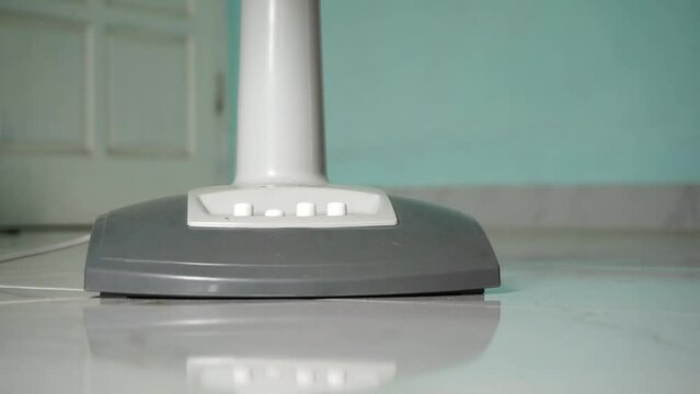 Hand turning on and off an electric air fan. Electric fan cooler turned on with pressing the button. on and off button of a fan