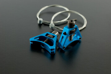 Blue color anodized aluminum triangle cantilever brake cable hangers spare parts for bicycle on a black background.