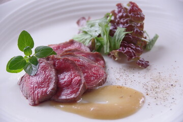 白い皿に盛りつけた牛肉のロースト