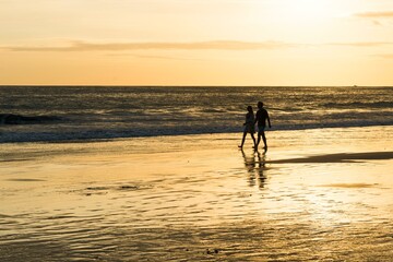 Fototapeta na wymiar Couple, Man and Woman, Walk on the beach, Sunset, Playa Espadilla, National Park Manuel Antonio, Costa Rica, Central America