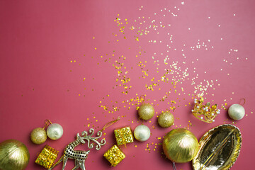 Golden Christmas background with gift boxes and decorations on red background. 