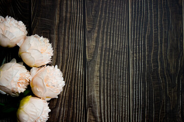 Pink flowers over the dark wooden table with copy space. 