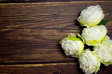 White roses over the wooden table with copy space. 