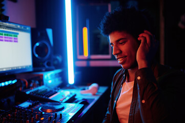 Glad music producer listening new track in headphones
